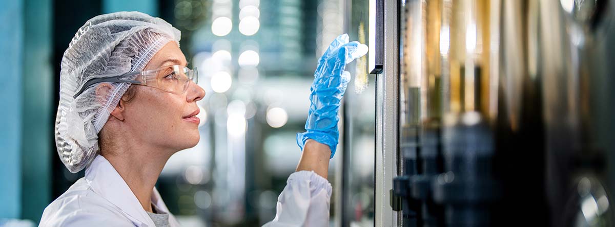 Image-Engineer monitoring the control panel on machinery in a manufacturing facility.