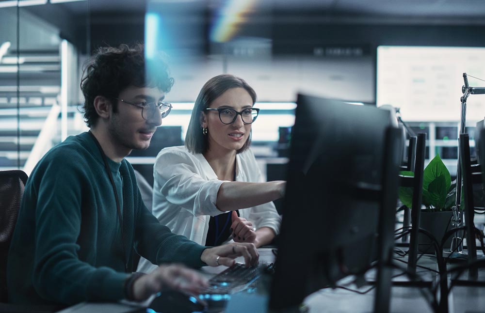 Image-Man and woman collaborating over computer