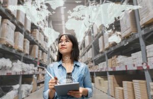 Image-Woman in warehouse looking at supply chain