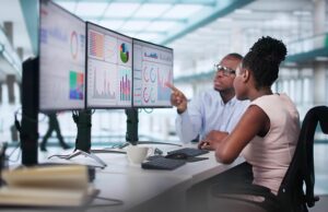 Image-Man and woman looking at product analytics on computer