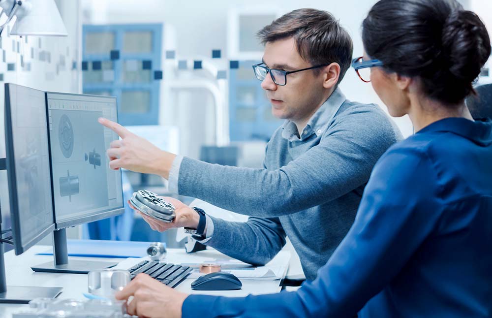 Blog-Top 5 PLM Integration Benefits That’ll Help You Stay Competitive Image-Engineer and Project Supervisor Comparing a Machine Part to a 3D rendering on Computer Screen