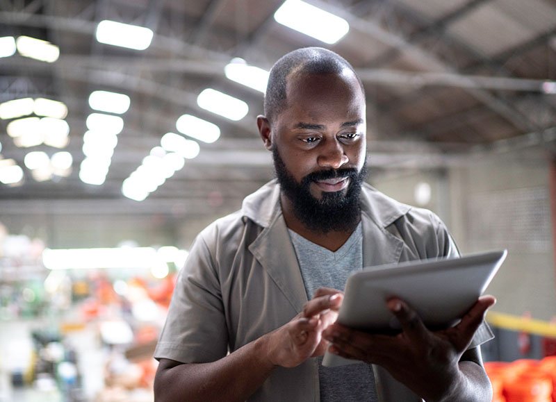 Man using a tablet in a manufacturing setting.