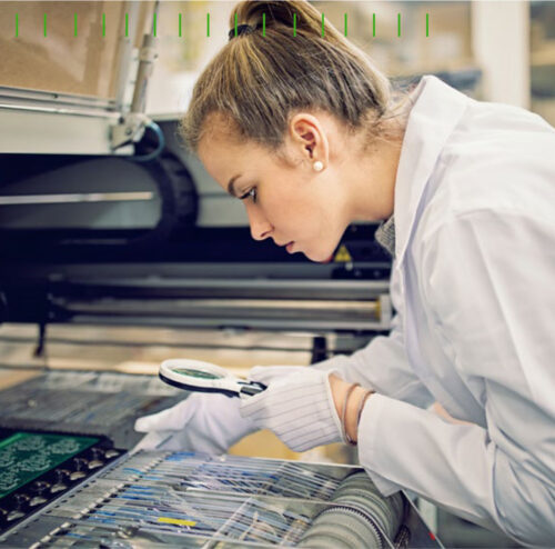 Engineer using magnifying glass to inspect components of a complex machine