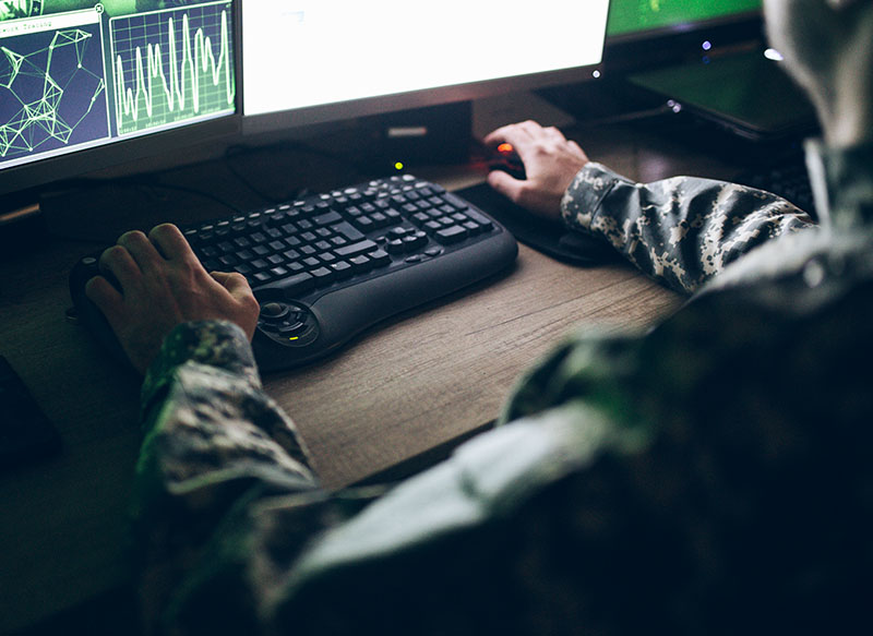 Image-Aerospace and defense personnel using multi-screen desktop computer
