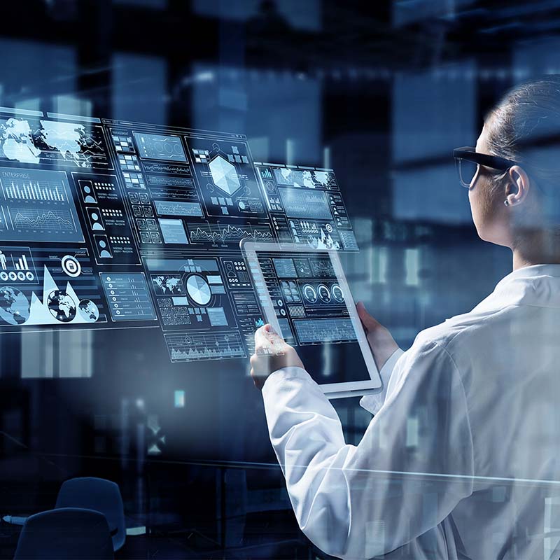Image-Medical engineer using tablet in front of multiple displays.