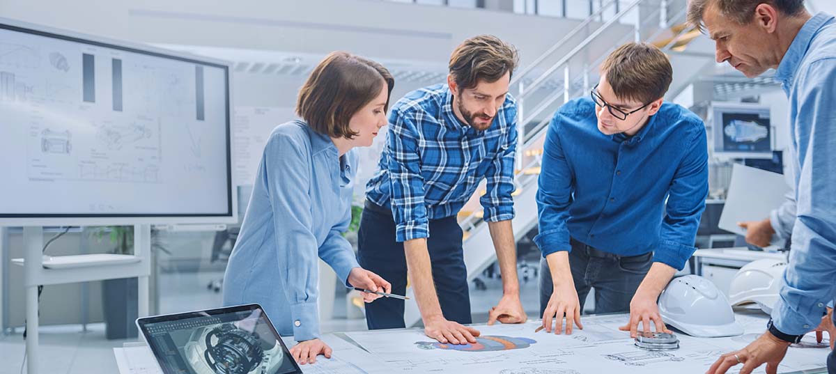 image-Team of engineers reviewing technical drawings in manufacturing setting