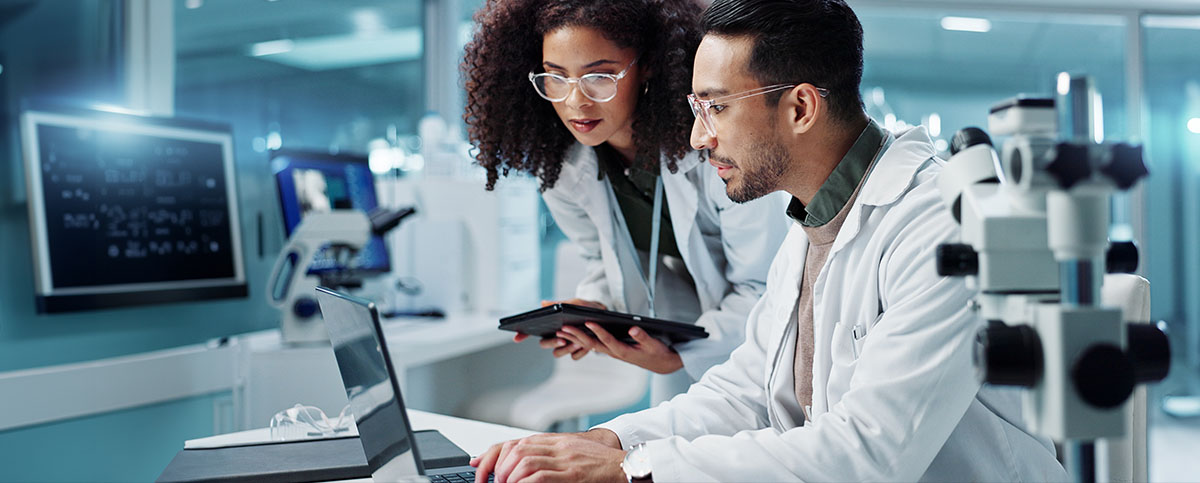 Image-Medical Engineers with a tablet collaborating in lab/product development space.