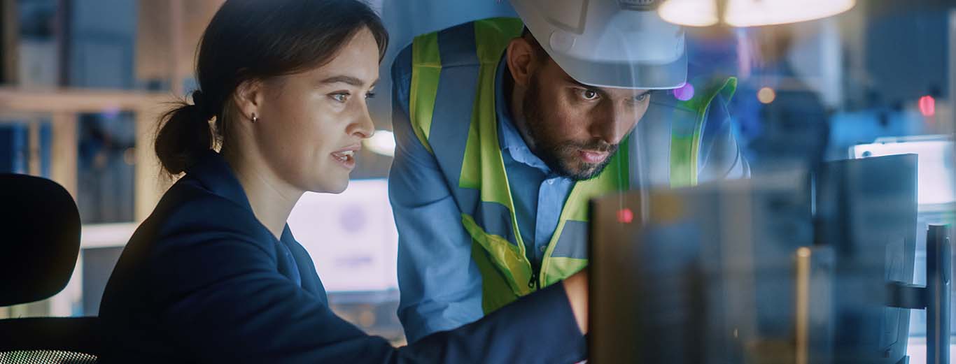 Image-Specialists collaborating at a computer in factory setting