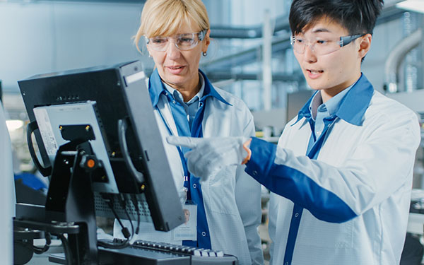 Image-Medical engineers collaborating at computer in lab setting
