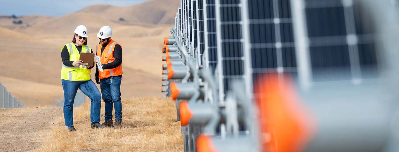 Image-Engineers reviewing a tablet next to a field of solar panels