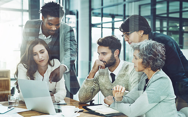 Image-Group of professionals collaborating around a laptop