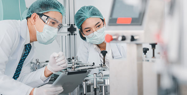 Image-Scientists examining factory machinery and materials used in the mask-making process
