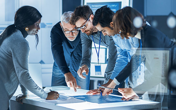 Image-Engineers, Scientists and Developers Collaborating Around Illuminated Conference Table