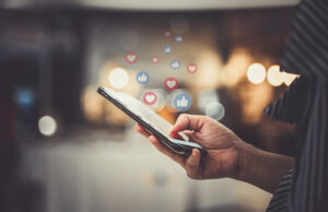 Image-Person using phone with social icons