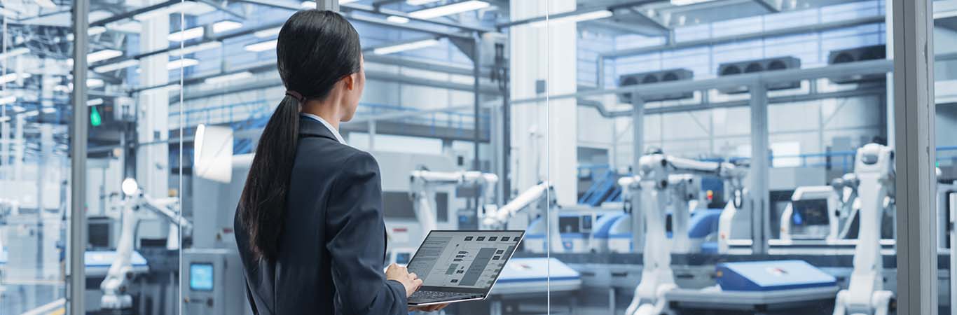 Image-Electronics manufacturing technician working on a laptop in a fFactory