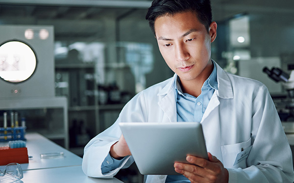 Image-Engineer/scientist using tablet in lab setting