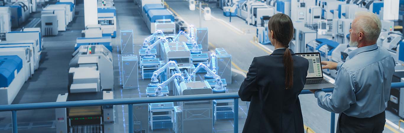 Image-Engineers Using laptop in a factory setting with VR overlay of robotics in an assembly line