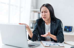 Image-Woman looking at laptop frustrated