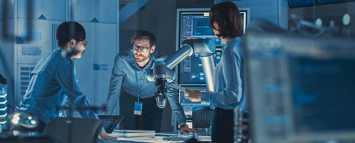 Image-Engineers with laptop and a tablet  discuss a robotic arm they are developing